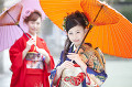 和傘を差す振袖姿の女性2人