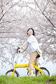 桜の下で自転車に乗って振り返る笑顔の女性
