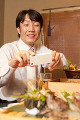 スマートフォンで料理を撮るビジネスマン