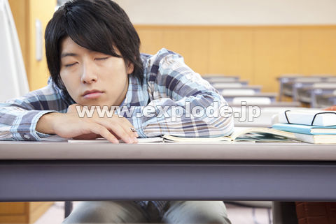 居眠りする男子大学生