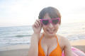 浜辺でサングラスをかけて微笑む女性