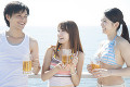 海辺でビールを飲む男女