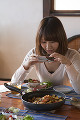 料理を携帯電話で撮影する若い女性