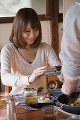 料理を携帯電話で撮影する若い女性