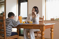 パジャマ姿で朝食を食べる母親と男の子