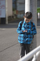 電信柱にもたれる小学生の男の子