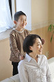 母親の肩を叩く男の子