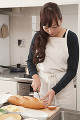 キッチンでパンを切る女性