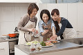 スマートフォンで料理を撮影する三人の女性