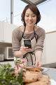 スマートフォンで料理を撮影する女性