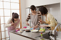 キッチンで弁当作りをする三人の女性