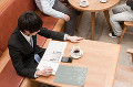 カフェで勉強するスーツ姿の若い男性