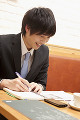 カフェで勉強するスーツ姿の若い男性