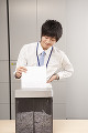 シュレッダーで書類を細断する若い男性