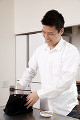 弁当をランチバックに入れる男性