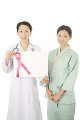 ピンクリボンのボードを持つ女性医師と患者