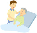 介護ベッドにもたれる老人男性と男性介護士