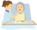 介護ベッドで食事をする老人女性と介護士