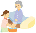 ベッドで足を洗ってもらう老人女性と介護士