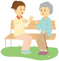介護士とベンチに座って話す老人女性