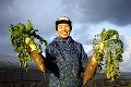 019：土のついた大根を持つ農家の女性