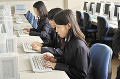 パソコンを操作する女子高校生三人