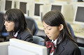 パソコンを操作する女子高校生二人