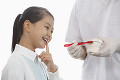 女の子とブラッシング指導をする歯科医師
