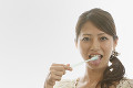 舌苔を除去する若い女性