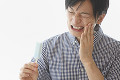 歯痛に顔をゆがめる若い男性