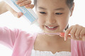 歯磨き粉を歯ブラシに付ける女の子