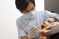 女の子の歯科検診を行う歯科医師