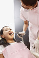 女の子の口腔内を洗浄する歯科助手