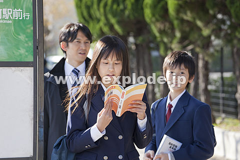 バス停で参考書を読む学生