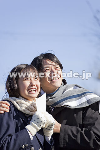 喜ぶ女子高校生と肩を抱く中年男性
