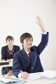 授業で手を挙げる男子中学生