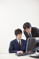 パソコンの指導をする教師と男子中学生