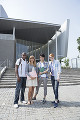 校舎の前で並んで立つ留学生と大学生