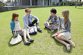 芝生に座る留学生と大学生の男女４人