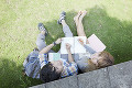 芝生に座り勉強する大学生と留学生
