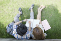 芝生に座り勉強する大学生と留学生