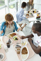 昼食を食べながら会話をする大学生と留学生